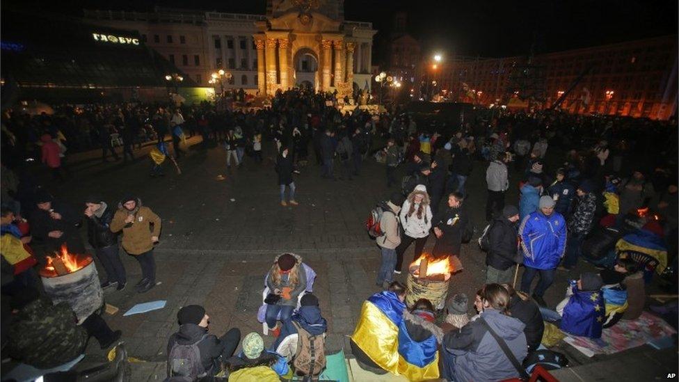 Ukrainian protesters gather over barrels with bonfires to warm themselves before police arrived.