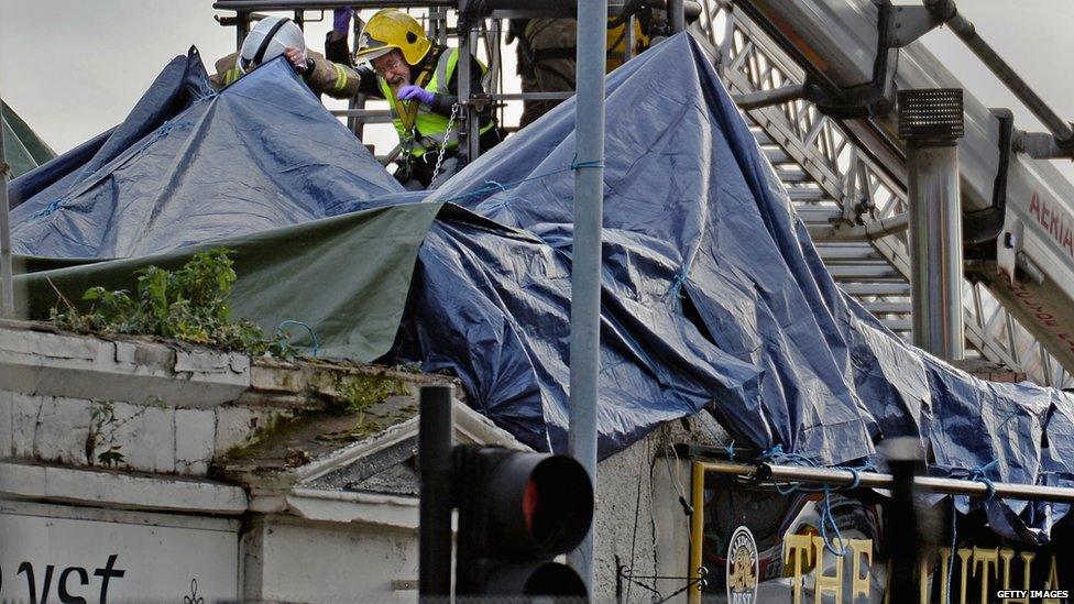 Rescue workers attend the scene at a pub on Stockwell Street where a police helicopter crashed on the banks of the River Clyde