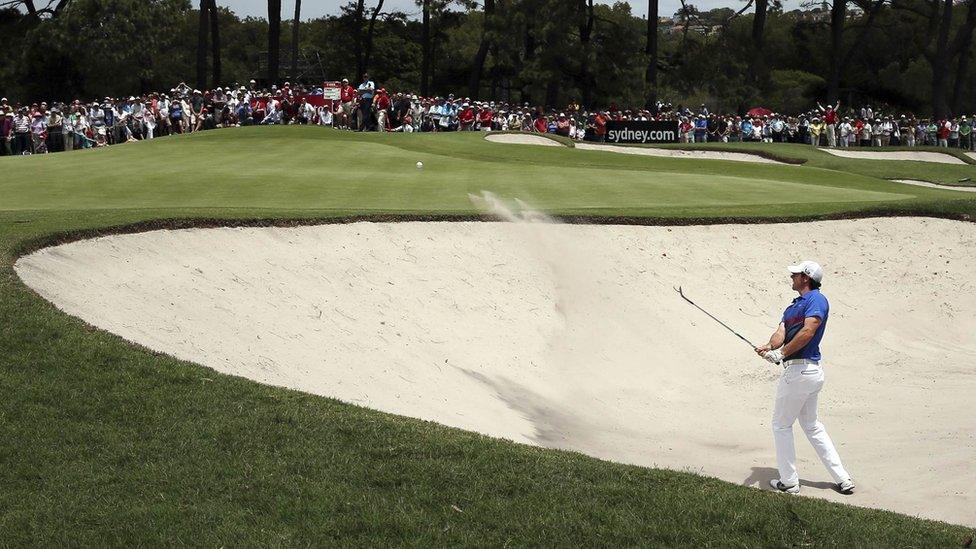 Northern Ireland's Rory McIlroy plays a bunker shot on the first hole - starting the final day of the Australian Open four shots behind home favourite Adam Scott