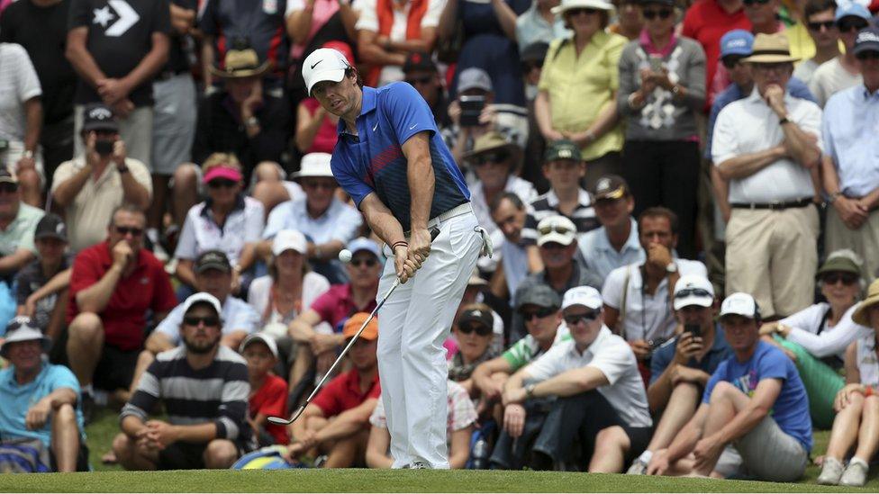 Spectators watch as Northern Ireland's Rory McIlroy hits a chip shot on the second hole during the fourth round of the Australian Open