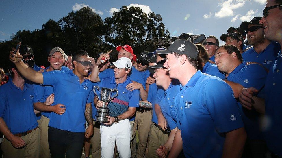 Rory McIlroy celebrates with green staff after his victory at the Australian Open