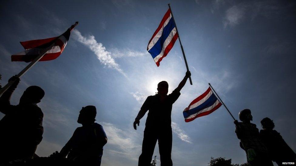 Anti-government protesters wave Thai national flags after they toppled barricades near the Government House in Bangkok, 3 December 2013