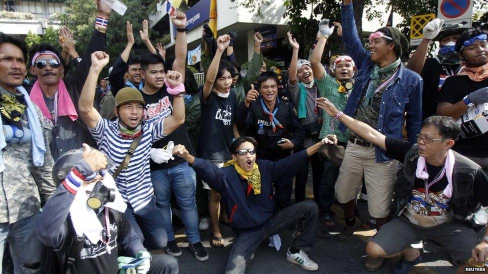 Anti-government protesters pose with riot police during a rally outside the Government House in Bangkok, 3 December 2013