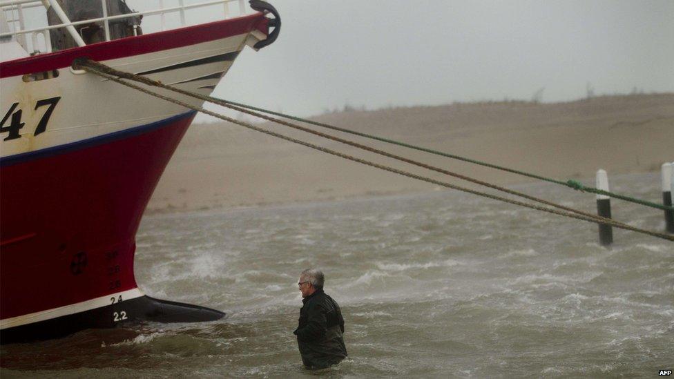 Man secures his boat on the west coast of Jutland, Denmark (5 Dec)