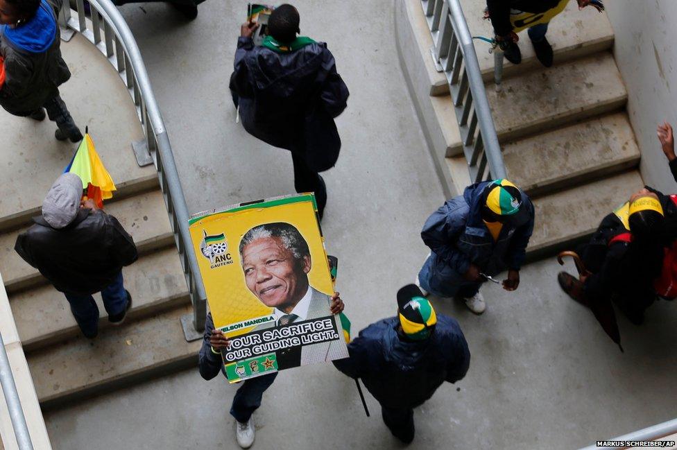 A man carries a poster as he arrives for the memorial service