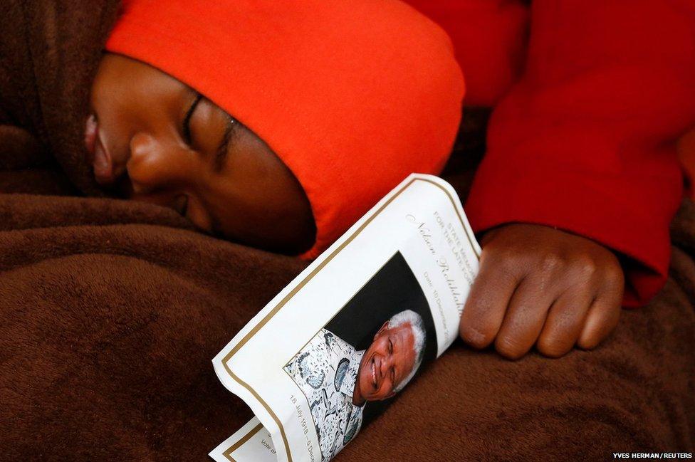 A boy sleeps on his mother's lap