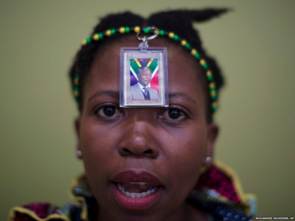 A woman wears a photo of former South African president Nelson Mandela