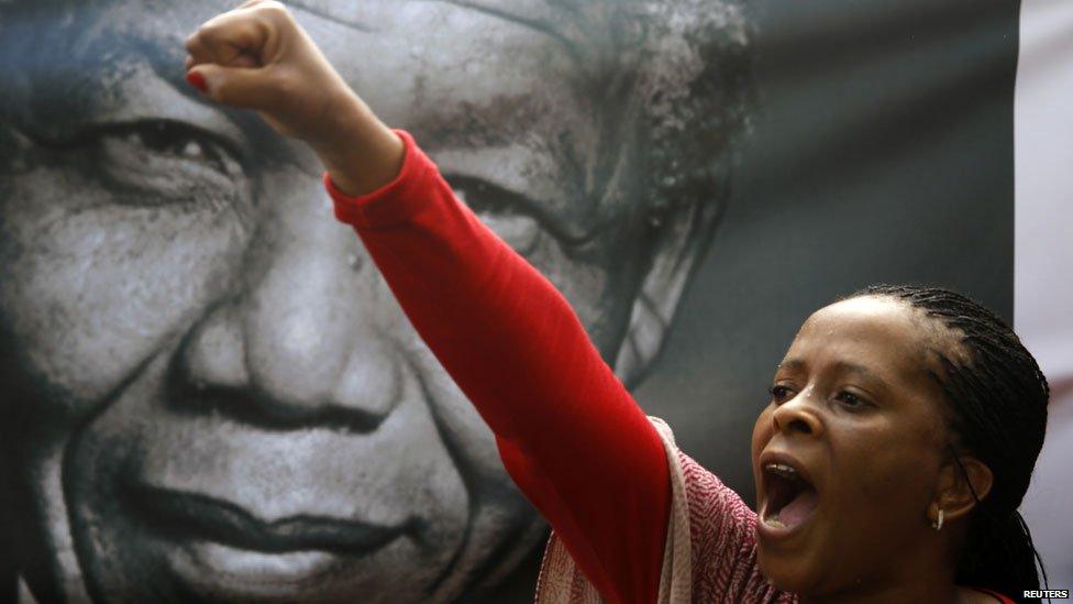 A mourner shouts Viva Mandela by a portrait of Nelson Mandela soon after the coffin of former South African President Nelson Mandela travelled through a street in Pretoria, December 11