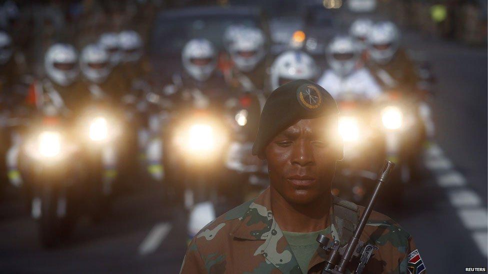 A soldier guards a closed road as military outriders escort the funeral cortege carrying the coffin of former South African President Nelson Mandela close to the Union Buildings in Pretoria December 11