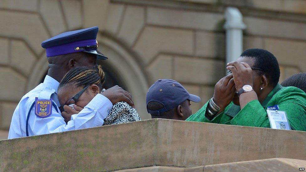 People cry after bidding farewell to South African former president Nelson Mandela lying in state at the Union Buildings in Pretoria on 11 December