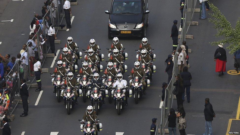 Police outriders escort the car carrying Mandela's coffin from the military hospital.