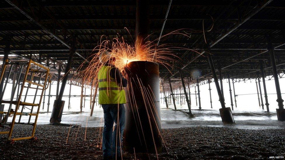 Restoration worker welding the pier column