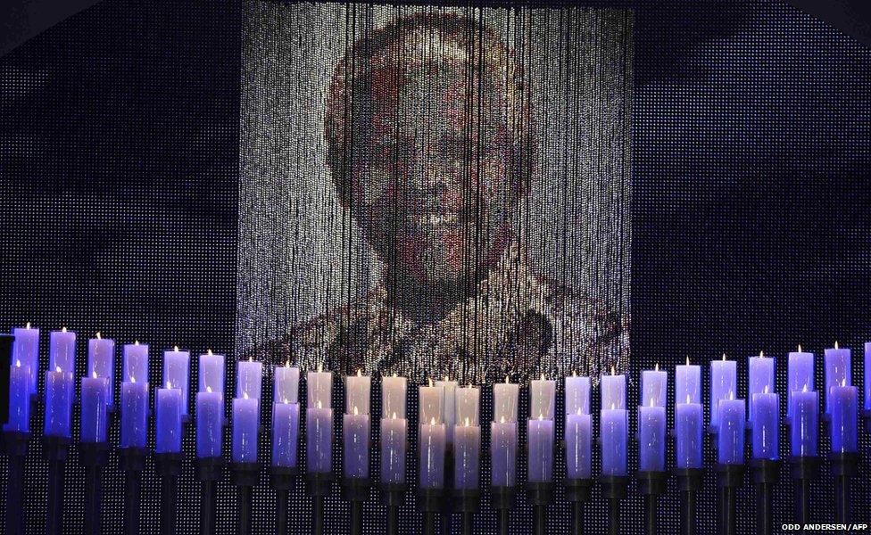 Candles are lit under a portrait of former South African President Mandela