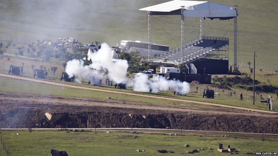 South African National Defence Forces fire ceremonial cannons as the body of Nelson Mandela is brought from the family home to the funeral tent