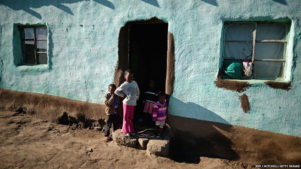 Children wait outside as they prepare to watch the funeral