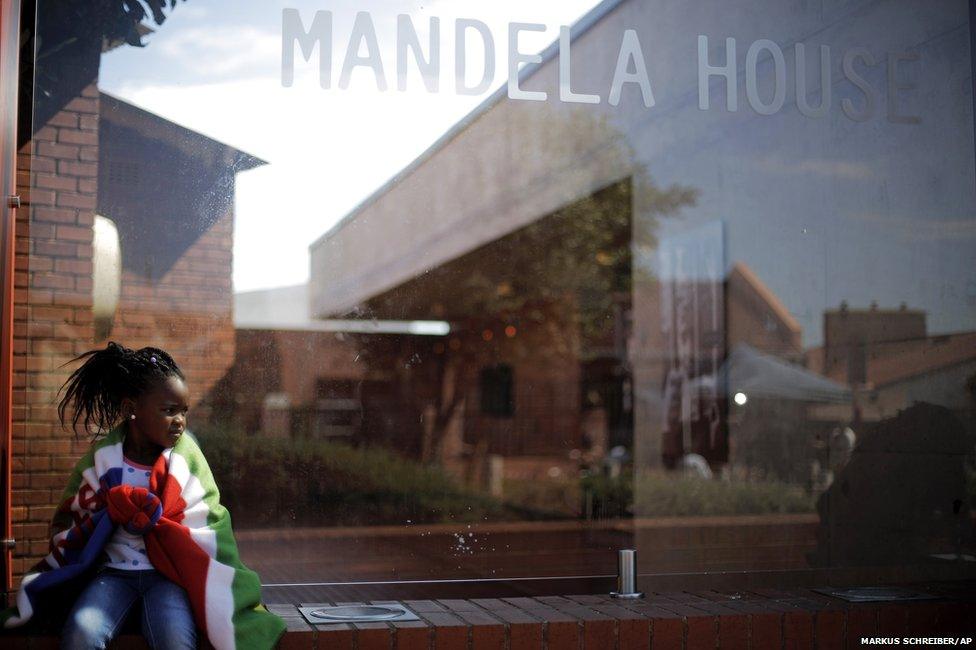 A girl sits outside the Mandela House Museum in the Soweto