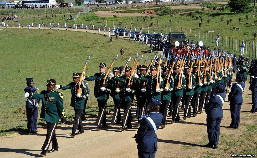 The casket of Nelson Mandela is brought in a military parade on a gun carriage from the family home to the funeral tent