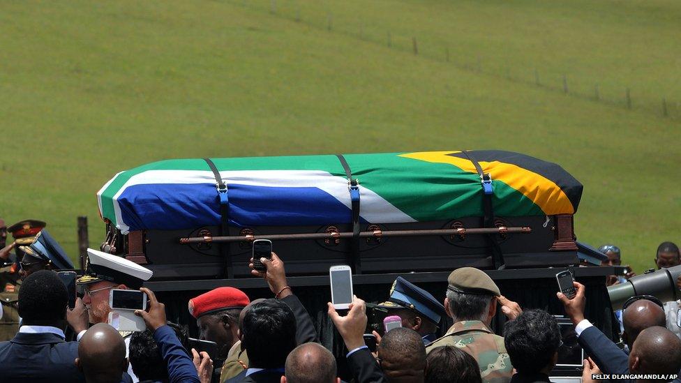 People take photographs of the casket