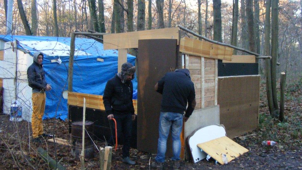 Roma people rebuilding huts after their camp was destroyed