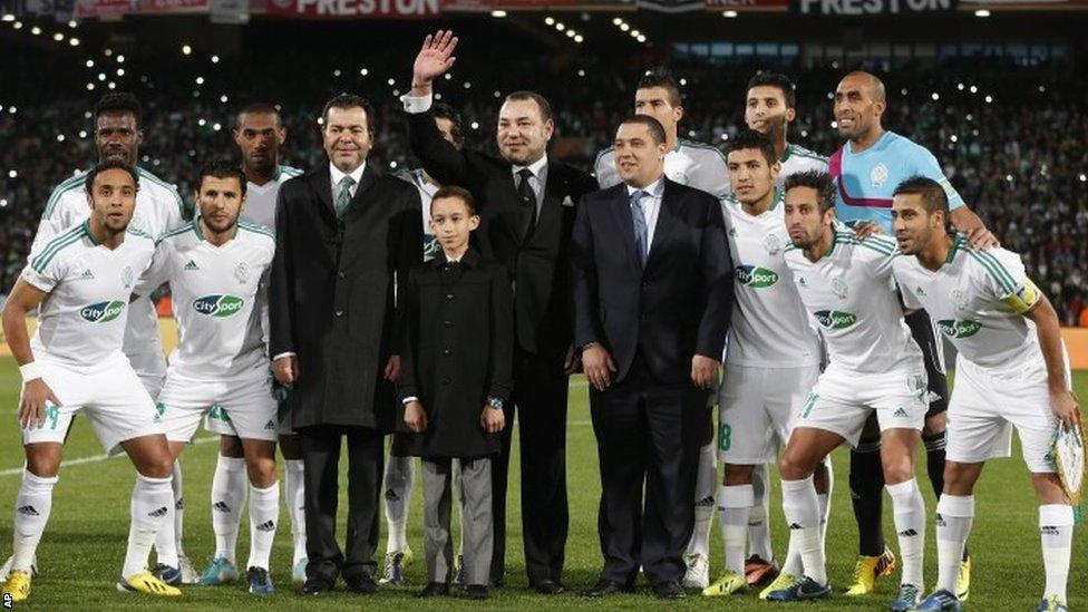 Moroccan King Mohammed VI poses with the team of Raja Casablanca prior to the final of the Fifa Club World Cup between Bayern Munich and Raja Casablanca in Marrakech