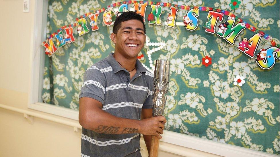 The Queen's Baton Relay arrives in a local hospital in Niue, as staff members pose for a photograph with the baton.