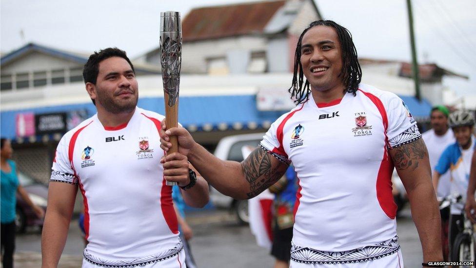 Tonga National Rugby League team members Konrad Hurrell (left) and Fuifui Moimoi (right) carry the Queen's baton in Nuku’alofa, Tonga.