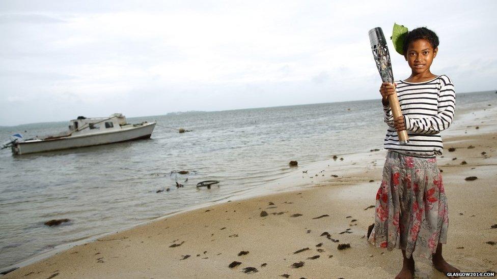 Christina Takitaki, holds the Queen's baton on the beach in Nuku’alofa, Tonga.