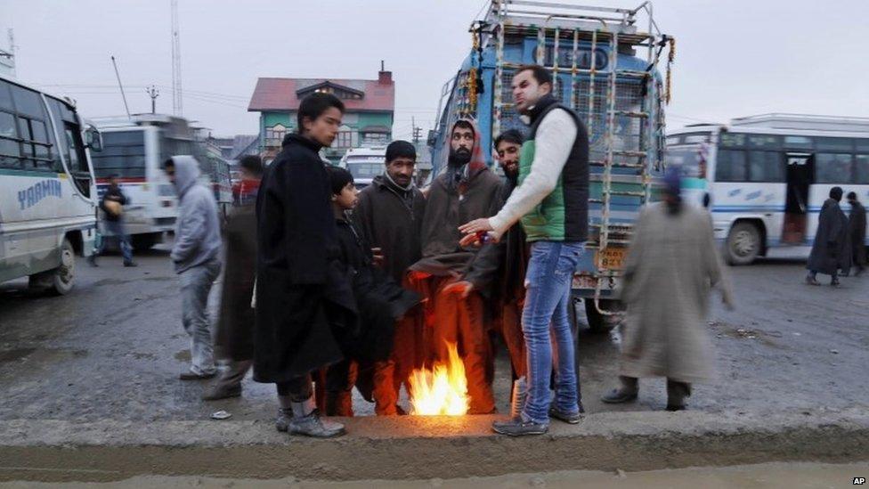 Kashmiri men warm their hands near a bonfire on a cold day in Srinagar, India, Monday, Dec. 23, 2013.