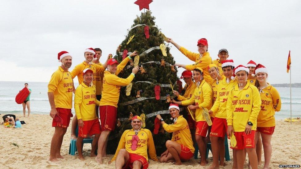 Bondi lifeguards pose in front of their Christmas tree at Bondi Beach on 25 December 2013 in Sydney, Australia