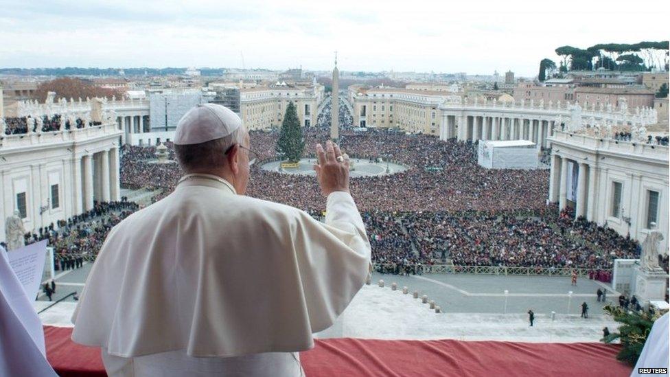 Pope Francis waves from the balcony overlooking St Peter's Square at the Vatican on 25 December, 2013