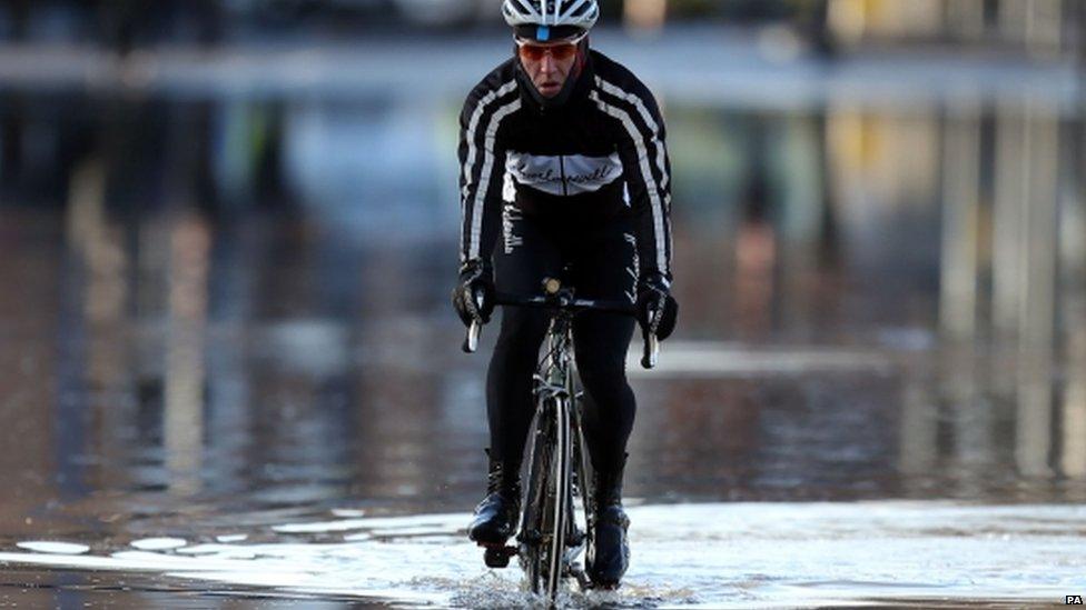 Cyclist riding through flood water