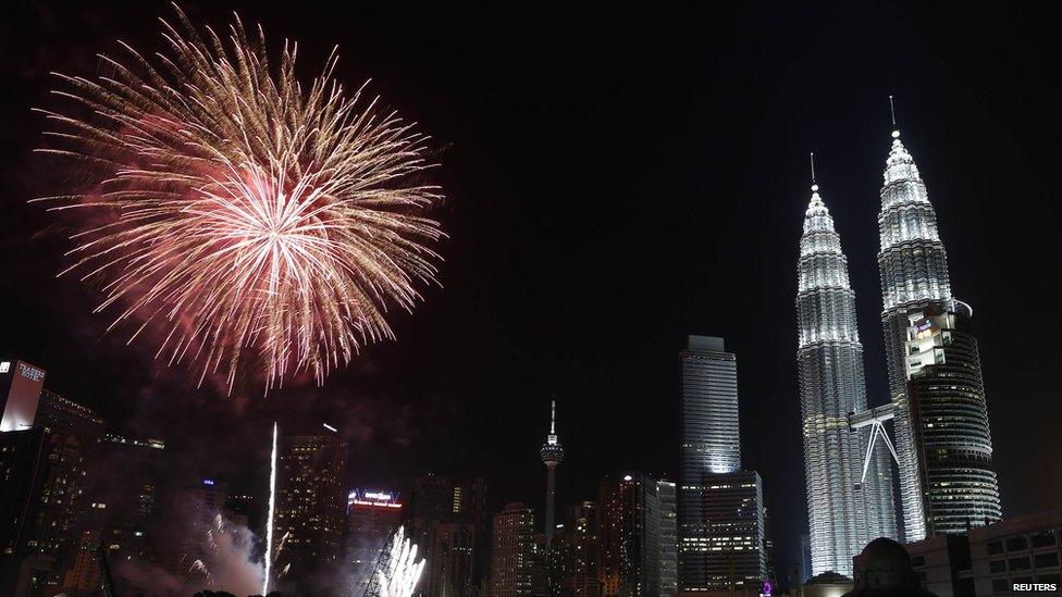 Fireworks explode near Malaysia's landmark Petronas Twin Towers during New Year celebrations in Kuala Lumpur January 1, 2014