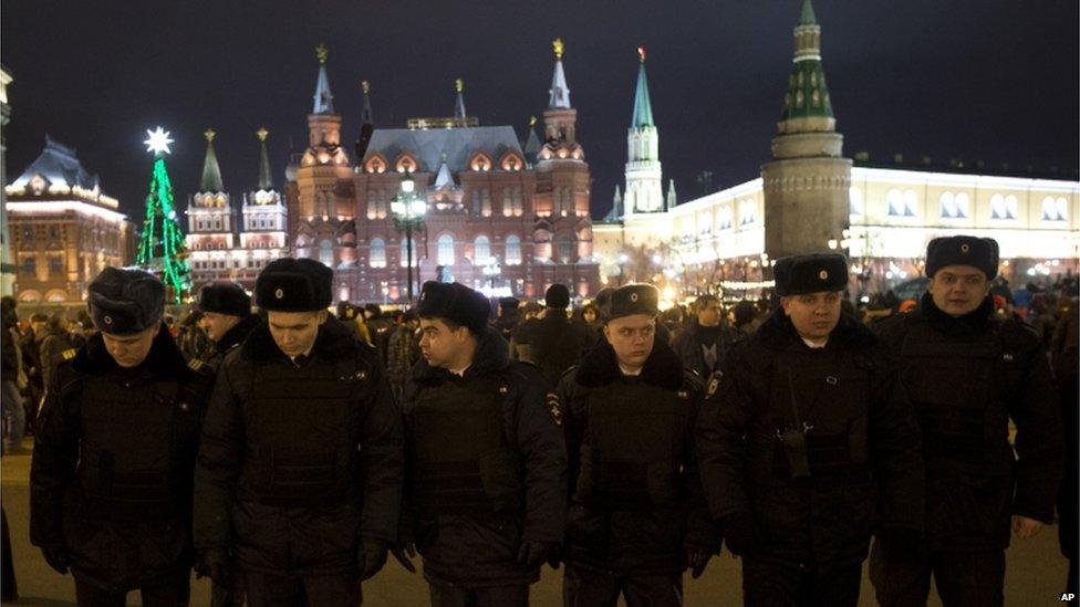 Russian police officers get ready to check people arriving at the Red Square ahead of the New Year's Eve festivities, in Moscow, Russia, Tuesday, Dec. 31, 2013.