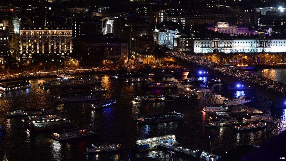 Crowds gather on the Embankment and Waterloo Bridge over the River Thames to watch the new year's fireworks