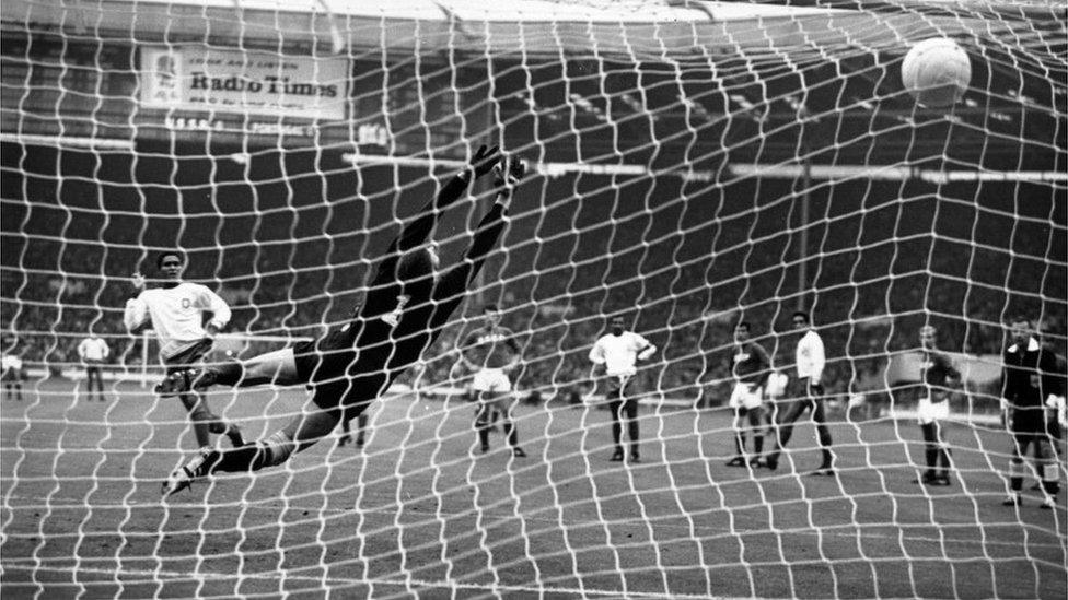 Eusebio (L) hammers his penalty kick past Russia's Lev Yashin, to put his country in the lead during the World Cup third place play-off game at Wembley, 29 July 1966