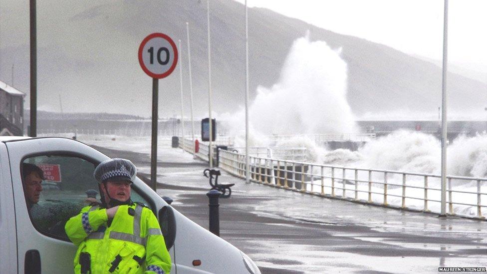 Police officer chats with van driver at seafront