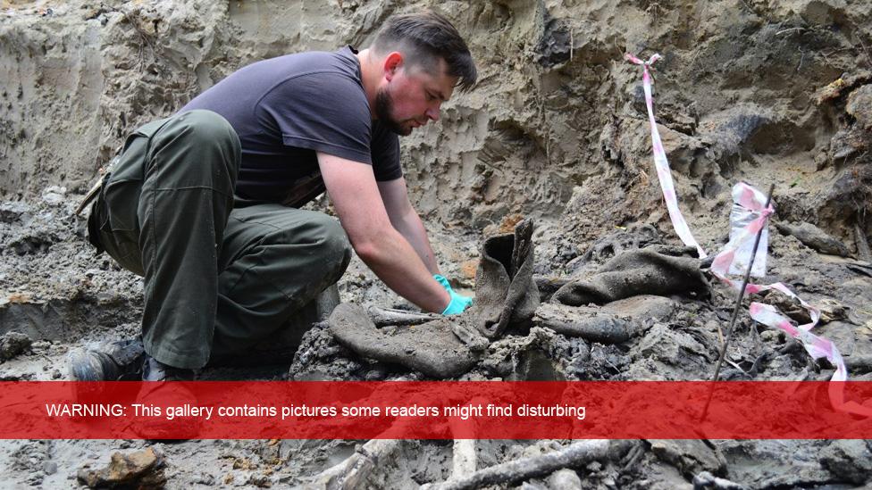 Man digging in mass grave