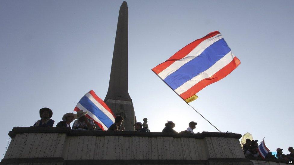 Anti-government protesters with national flags take positions at a rally at Victory Monument on 13 January 2014