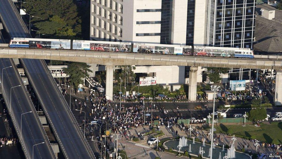 An elevated train passes over an intersection that is being blocked by anti-government protesters in Bangkok on 13 January 2014