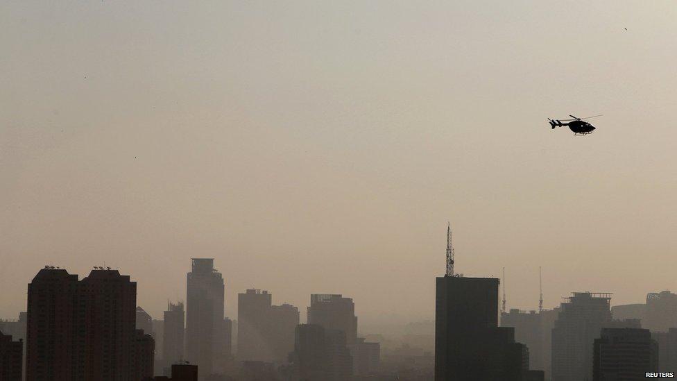 A helicopter flies over the central part of Bangkok on 13 January 2014