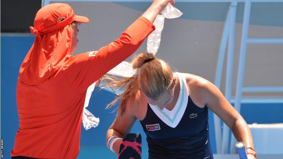 Dominika Cibulkova of Slovakia gets bags of ice around her shoulders to cool off in the heat