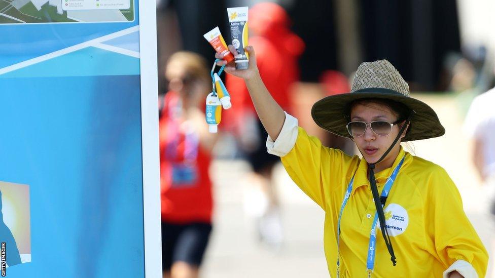 A vendor holds sunscreen as Melbourne heads towards 43C