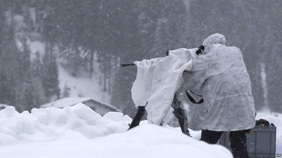 A member of Swiss special police forces manning a machine-gun on the roof of the Congress Centre in Davos