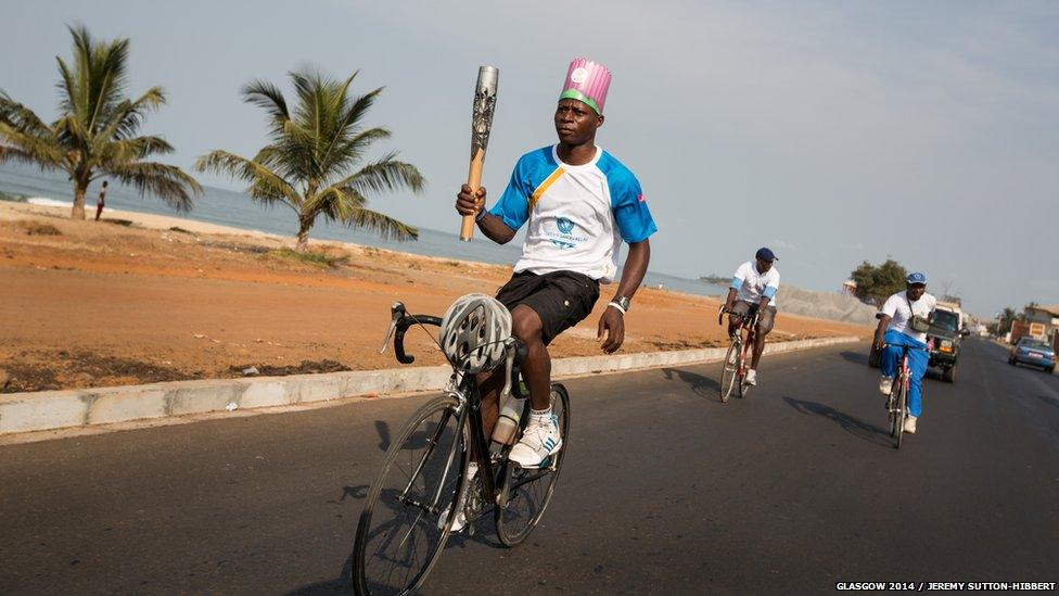 A cyclist takes the baton through the streets of Freetown, Sierra Leone