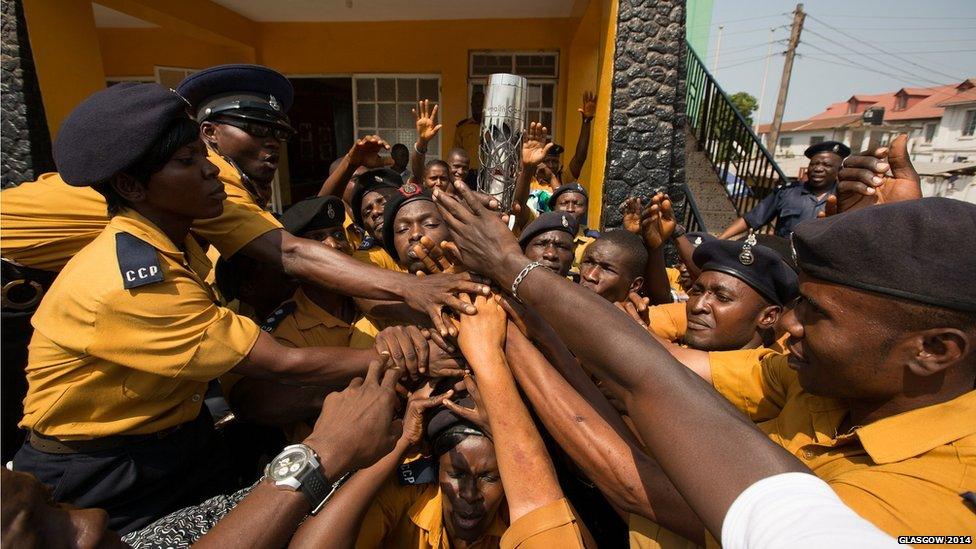 The Queen's baton is held by members of the Metropolitan Police during the relay in Freetown, Sierra Leone.