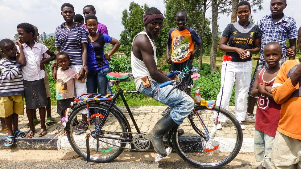 The crowds wait patiently for the Queen's baton, including one local in a heavily customised bike.