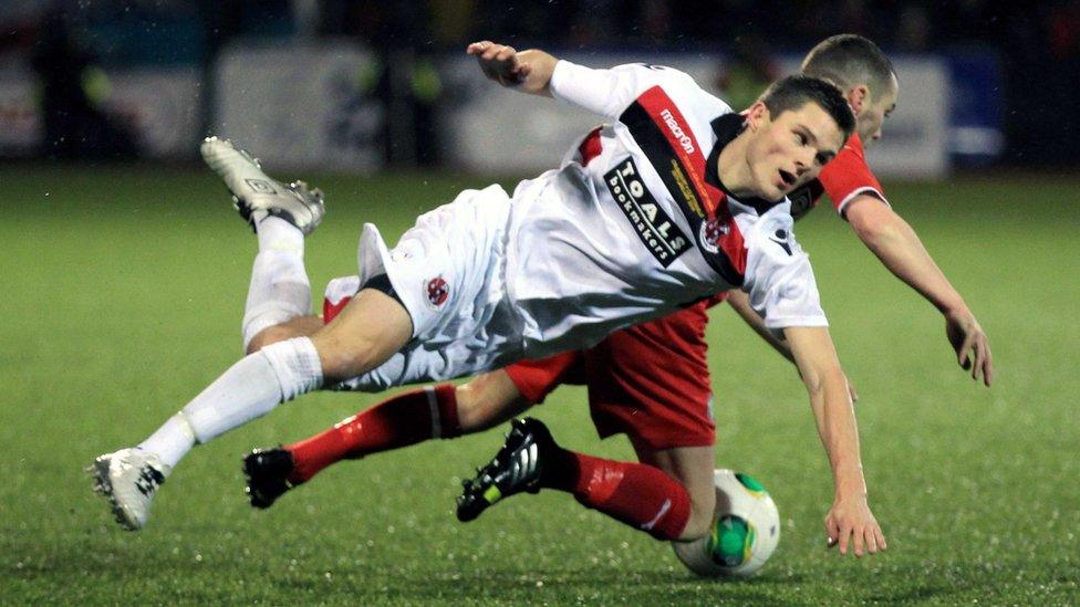 Crusaders defender Craig McClean hits the deck along with Cliftonville opponent Martin Donnelly at Solitude