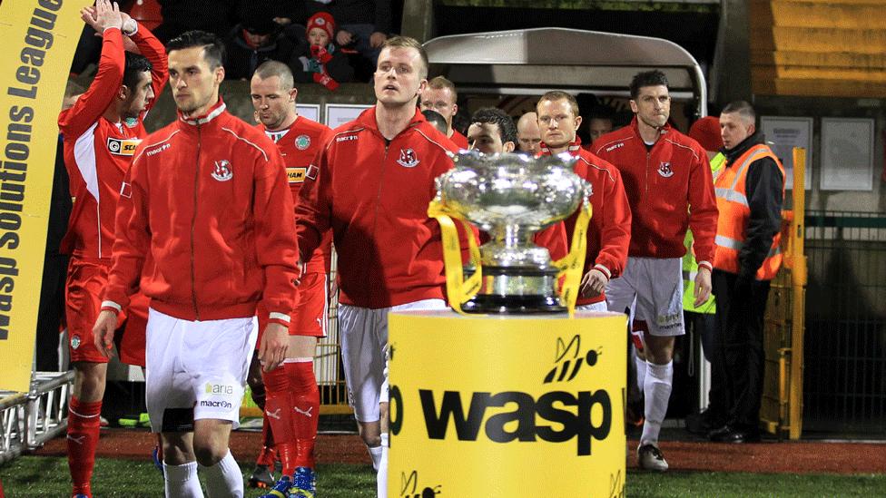 The Crusaders and Cliftonville teams walk out for the 2013/14 NI League Cup final at Solitude