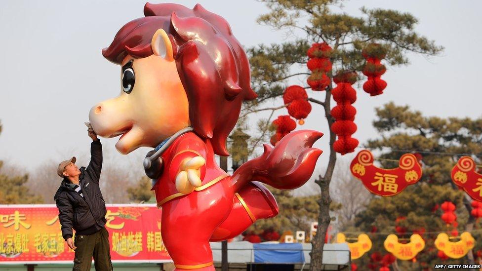 Worker putting the final touches on a cartoon horse in China