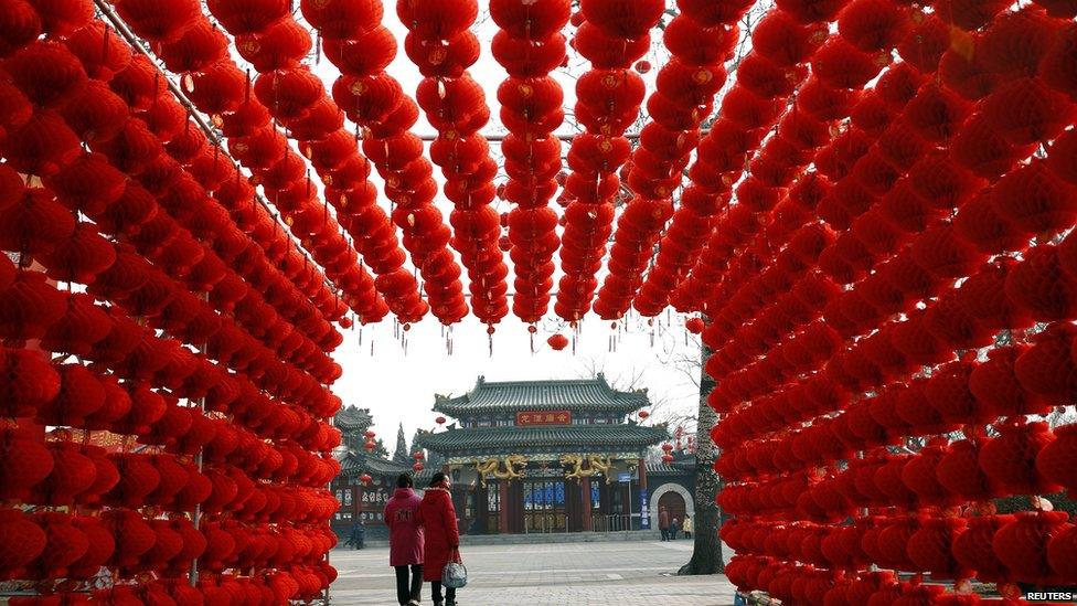 Visitors walk past red lantern decorations at Longtan park